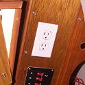 The area that was previously the DC hub is now the AC hub, with a custom made breaker panel.  The main switch feeds the other breakers as well as the duplex outlet above it.  This outlet is tied directly to the shore, and so the "ground" is an electrolysis  consideration/problem.  Basically, it will ONLY be used short term, and only when people are present, typically for tools.  Anything left on and unattended will be connected to the only other duplex outlet on board, which is connected to an isolation transformer.  Middle breakers power the battery charger, also isolated.  And that's it for AC; this is a sailing vessel, not a docking vessel.