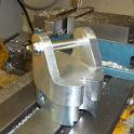 Here's endcap with a whole lot of metal milled away to make the ears.   Actually, the bandsaw was used to remove most of the material, as sawing is much faster than milling.   Once the milling was complete, almost 4 hours was spent filing.  Most of the time was used to remove all the machining marks, the rest was spent shaping the inner oval so that it was a nice snug fit inside the boom extrusion.   (That's the blue "paint" you see; it's not paint at all, it's machinist's blueing that I didn't clean off completely.  It's used to determine where things are tight.  Shove the part in, see where the blueing rubs off, file .. paint .. shove .. look, file .. paint .. shove  .. look, over and over and over again!)