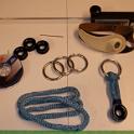 Here's the various bits and pieces used to turn conventional slab reefing into single sided slab reefing.  I made some loops out of Amsteel and then attached them to some low friction Ronstan "Ropeglide" rings.  The rings that are apparently made out of brass are in fact stainless steel; a quirk of the lighting makes them look gold.  These rings are slightly larger in diameter than the existing cringles and are about as neat a solution as can be had.
