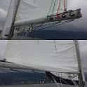 One last fix.  I was convinced by .. someone .. that single sided slab reefing was better than conventional slab reefing in terms of kindness to the sail; conventional slab reefing just scrunches the sail up between the reefing lines.  Single sided reefing allows the excess sail to fall nicely to one side.  Single sided slab reefing should also improve the sail shape when reefed.  In the top half of this pic, you see all the lines running down the same side of the sail.  The bottom half shows the other "clean" side.  I left the unused pad eyes on the boom, just in case I change my mind about this.