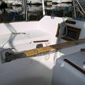My original tiller.  Quite aside from NEEDING refinishing, it had other problems.  First, by being straight and mounted low, it had to be lifted significantly to be used, effectively shortening it.  I could manage it, but Savannagh had some problems with the reduced leverage in heavy seas.  More importantly, I wanted to add an autopilot.  This meant the tiller had to be fully horizontal, but when horizontal, the angular travel was limited by the lazarettes.  A new tiller was clearly called for, but a custom tiller was going to be WAY too expensive for my budget.
