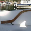 So I found a big block of solid mahagony, got out my jig saw and carved out a tiller.  Sand sand sand varnish varnish varnish and .. not quite done.  The original tiller had a couple of big hex head bolts running through the stainless mount, fastened with nuts.  This meant sharp edges on both sides to snag lines and scratch ankles.  I decided to make some internal nuts, threaded all the way through, and use round head bolts from either side.  Here we see two bolts installed, one sitting there waiting to be installed.    The autopilot bracket is mounted here on the bottom, using cross drilled and tapped rod, the holes hidden with mahogany plugs.  Similar bolts and plugs are used to hold the tiller extension on the top.
