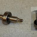Here's the first bearing pressed onto the shaft.  If you look hard, you can see the snap ring, installed before the bearing went on.  The keen eyed will notice that the bearings have a rubber seal, making them 6202RS2 type bearings.  While this type of bearing is not rated for as high an RPM as the stock 6202ZZ bearings with metal shields, a close examination of the specs showed they should be just fine at the RPMs this pump will run at.  More importantly, if the front seal does start to leak again, the rubber could provide a bit of protection.  The inset shows the gauge in use, to set the bearing location on the shaft.  You'll also note the shaft is quite a bit shinier than in previous pics.  It too saw time in the lathe with some steel wool.  Thankfully, there was only a small score in the shaft in the area of the seal, and a 30 seconds with steel wool removed the mark without appreciably thinning the shaft.